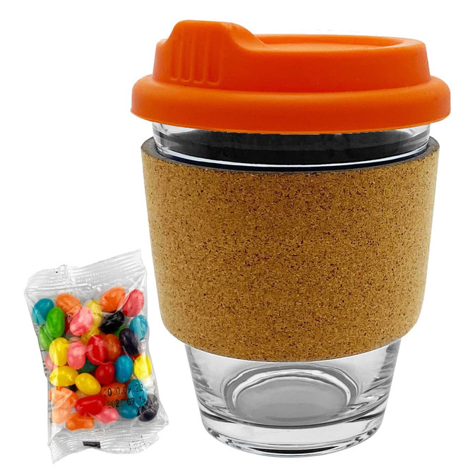 A glass coffee cup with an orange lid and cork band, accompanied by a bag of colourful jelly beans.