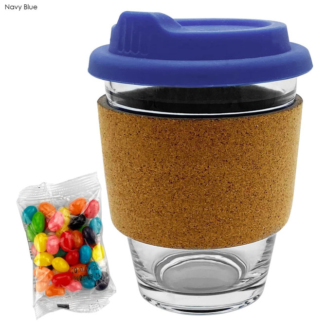 A glass coffee cup with a navy blue lid and cork band, accompanied by a pack of colourful jelly beans.