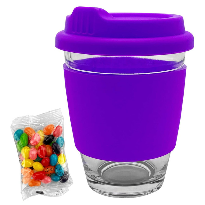 A purple glass coffee cup with a silicone lid and sleeve, accompanied by a packet of colourful jelly beans.