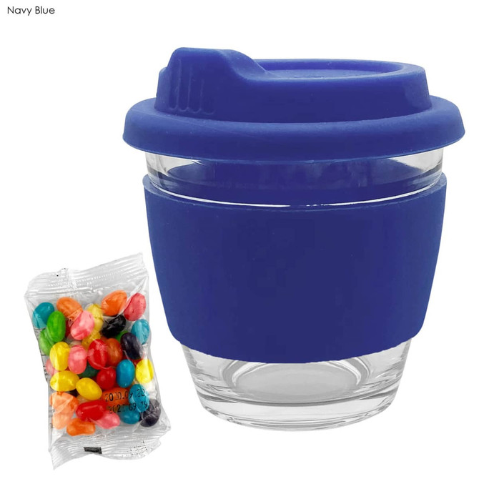 A reusable coffee cup with a navy blue silicone sleeve and lid, accompanied by a packet of colourful jelly beans.