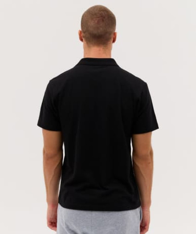 A black polo shirt with a simple design, viewed from the back, featuring short sleeves and a collar.