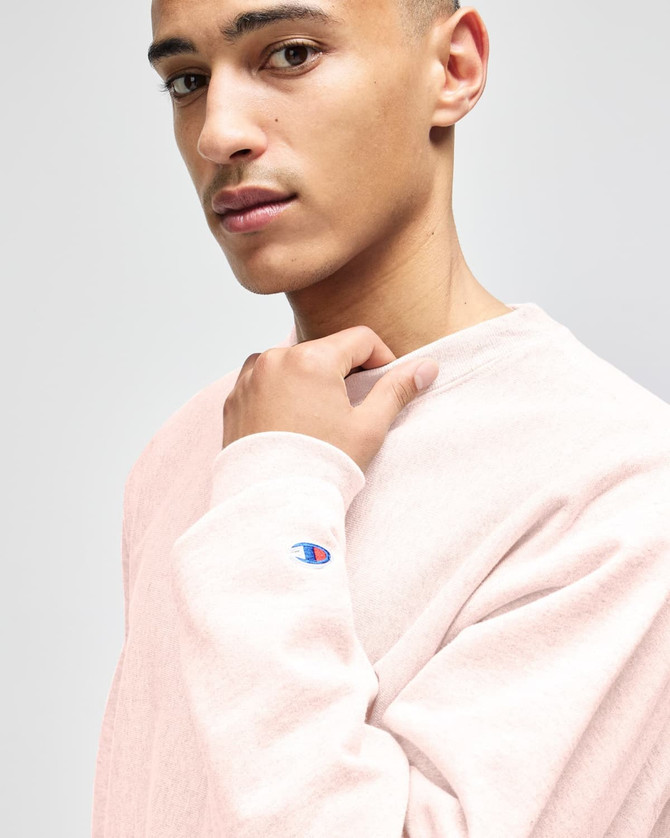 A model wearing a grey Champion Reverse Weave® adult crew sweatshirt, showcasing a casual style.