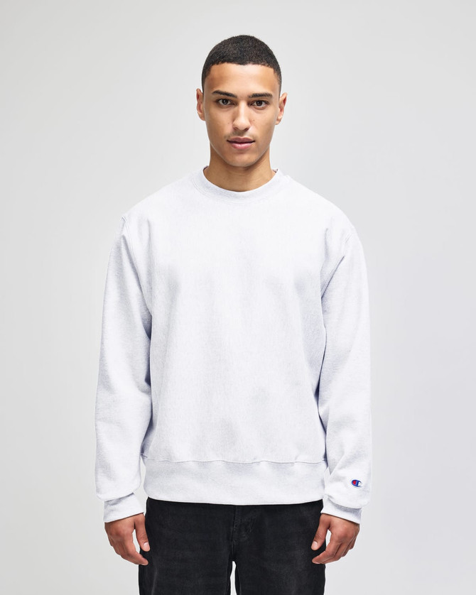 A light grey sweatshirt featuring a crew neckline and long sleeves, with a logo on the sleeve.