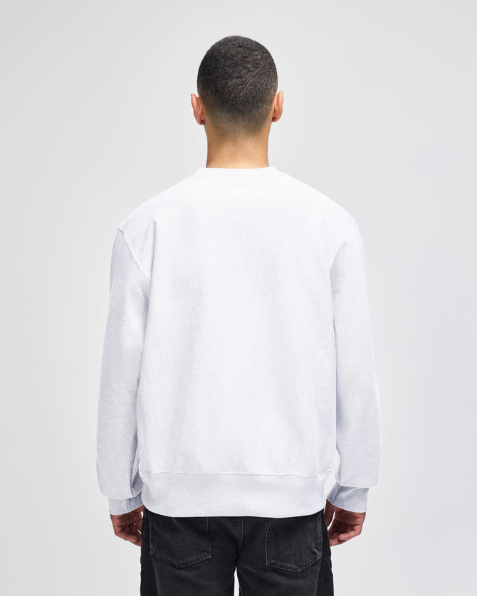 A white sweatshirt with a relaxed fit, featuring long sleeves and a simple design, viewed from the back.