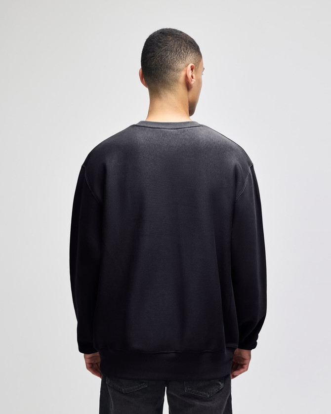 A black crew sweatshirt with a relaxed fit, featuring long sleeves and a back view. It has a logo.