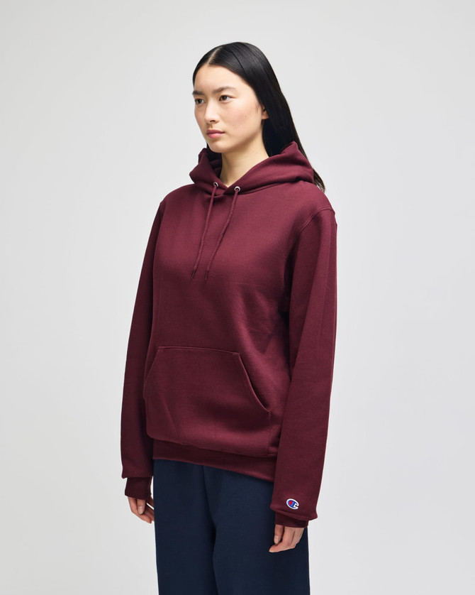 A maroon pullover hooded sweatshirt with a front pocket and logo branding, worn by a model.