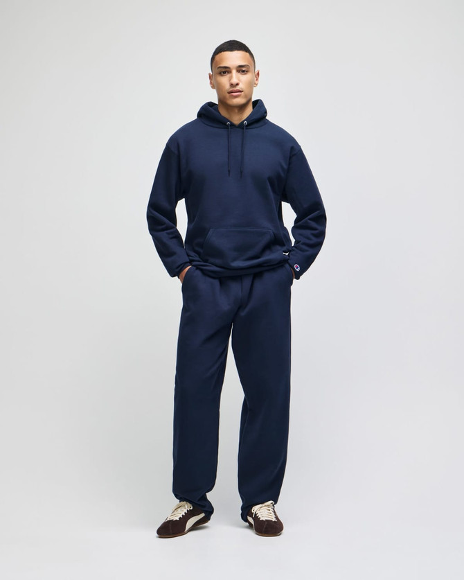 A navy pullover hooded sweatshirt paired with matching pants, featuring a logo on the sweatshirt.