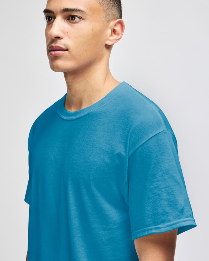 A model wearing a turquoise short-sleeve t-shirt with a relaxed fit. The shirt features a logo on the front.