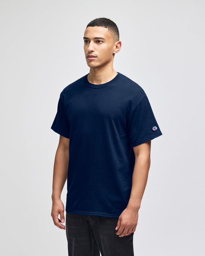 A navy blue Champion adult short-sleeve T-shirt displayed on a male model. Features a logo on the sleeve.