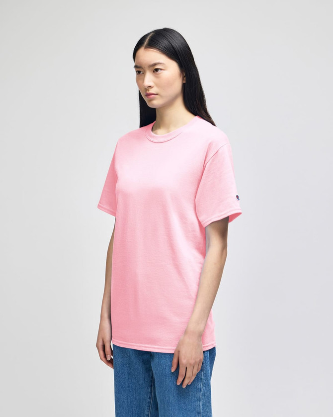 A pink Champion adult short-sleeve T-shirt, displayed on a model standing in profile.