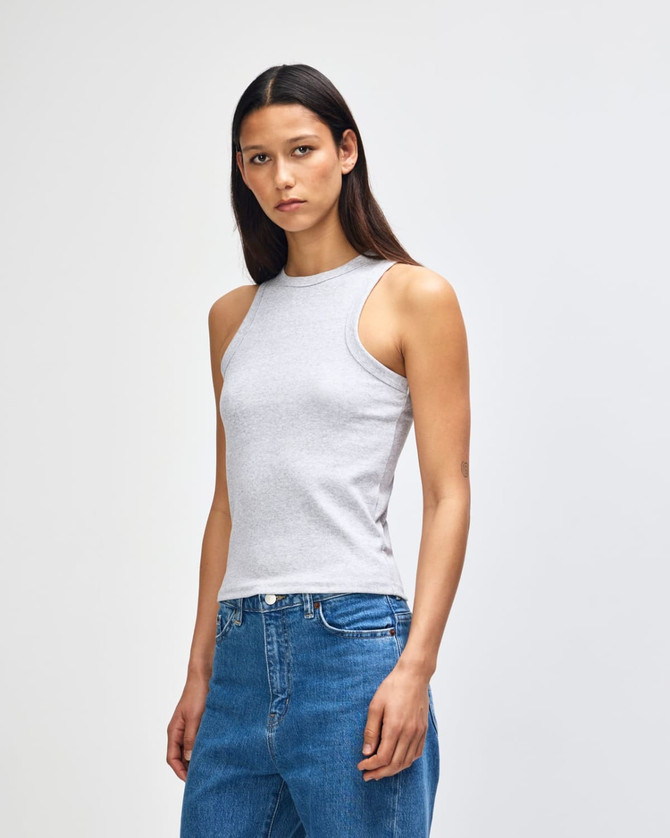 A fitted grey tank top on a model, paired with blue jeans. The top features a logo tag.