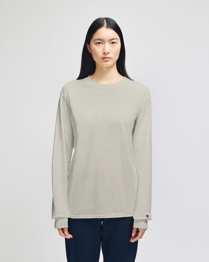 A light grey long-sleeve t-shirt for adults, featuring a branding logo. Modelled by a person with long hair.