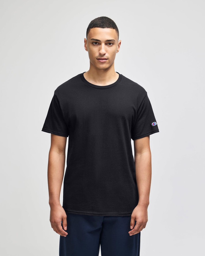 A black adult jersey short sleeve t-shirt with a logo on the sleeve, displayed on a model.