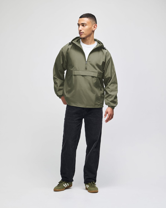 An olive green packable anorak jacket, featuring a hood and half-zip, worn by a model with black pants.