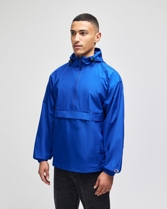 A blue packable anorak jacket with a hood, long sleeves, and a front pocket, featuring a logo.