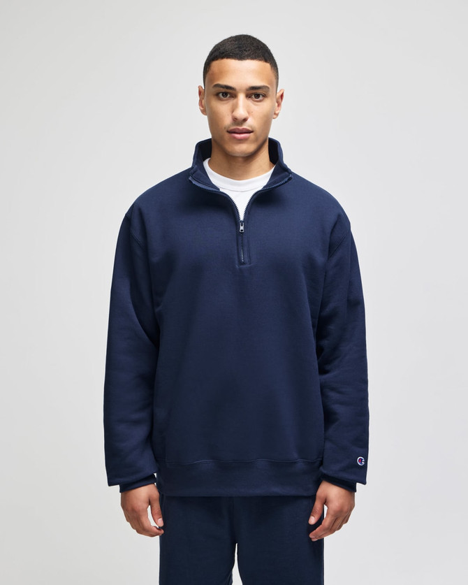 A navy blue quarter-zip pullover with a relaxed fit and branding on the sleeve.