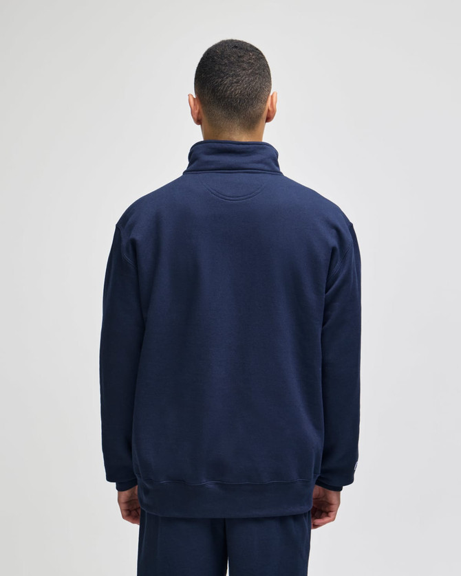 A navy quarter-zip pullover jacket viewed from the back, featuring a high collar and a simple design.