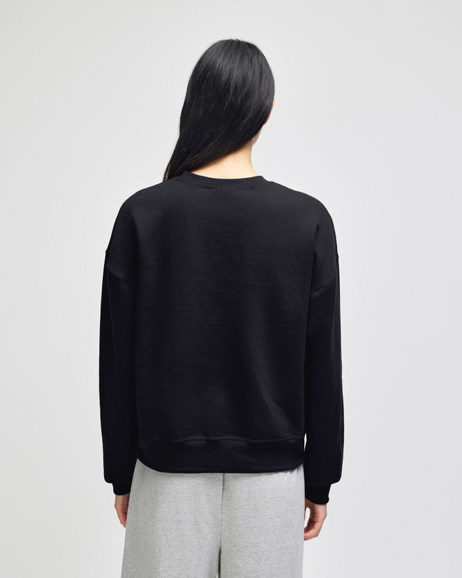 A black women's crewneck sweatshirt with a loose fit, featuring long sleeves and a simple design.