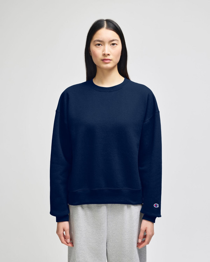 A navy blue women's crewneck sweatshirt with a relaxed fit and a branding logo on the sleeve.