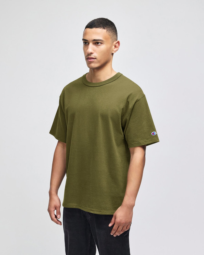 A relaxed-fit olive green t-shirt with short sleeves and a logo on the sleeve.