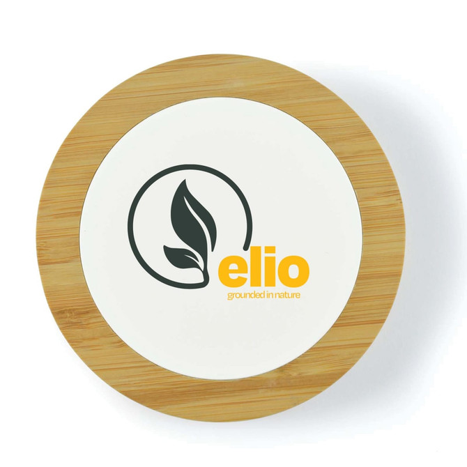 A round wireless charger with a bamboo border and a white centre featuring a logo and leaf design.