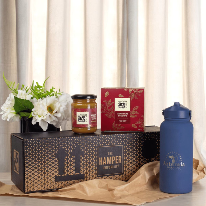 A blue drink bottle, a jar of jam, a box of biscuits, and a vase of flowers arranged on a decorative box.