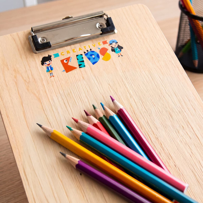 A wooden clipboard with a colourful logo and a set of vibrant coloured pencils arranged beside it.