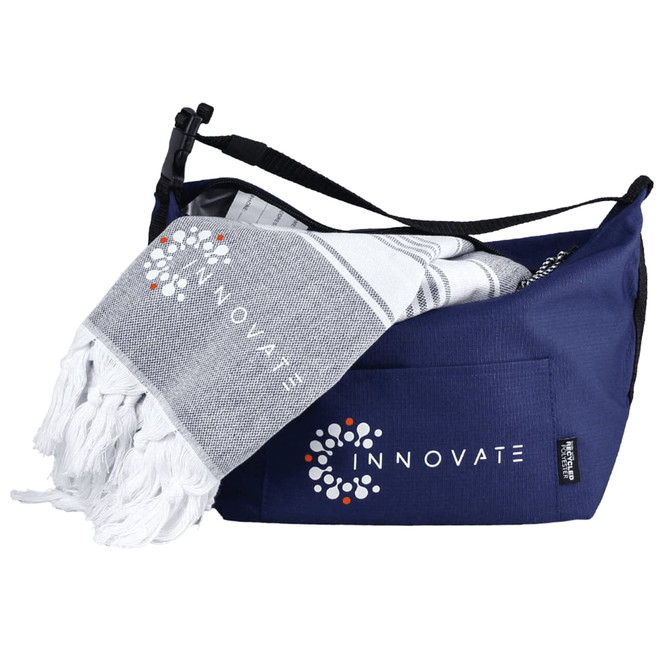 A navy cooler bag with a white and grey towel peeking out, featuring a logo on both items.