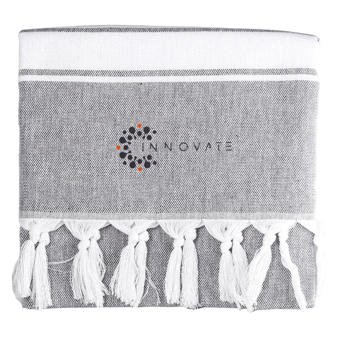 A grey towel with white fringes and a logo in the centre.