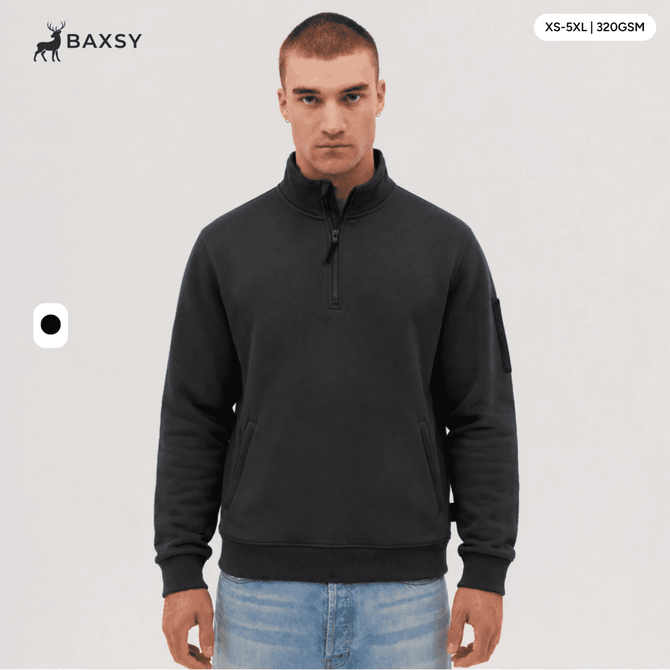 A 1/4 zip fleece in dark grey, featuring a logo on the sleeve. Model displays the product against a neutral background.