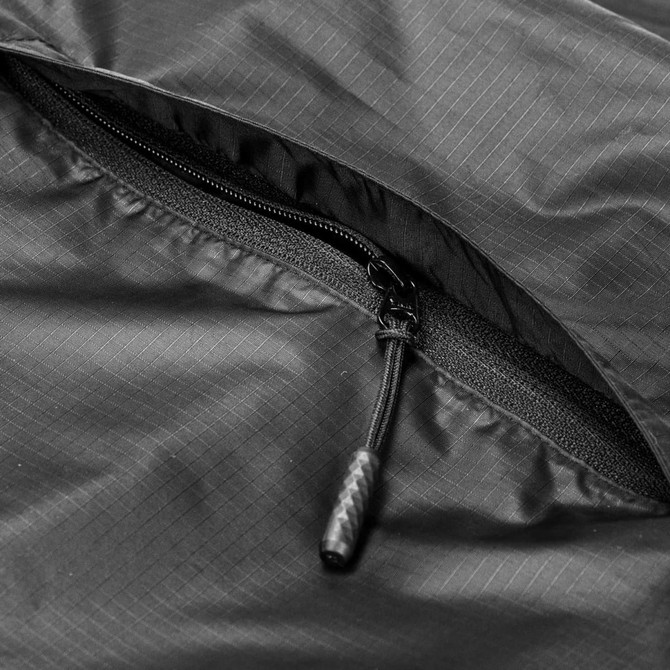 A close-up of a black windbreaker featuring a zipper, with a textured fabric design and a branding logo.