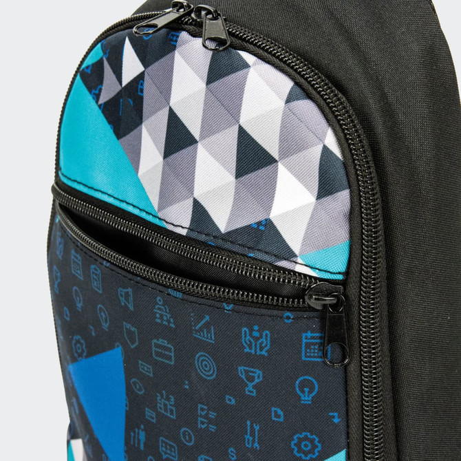 A crossbody bag featuring a geometric pattern in black, turquoise, and grey with zippered compartments and a logo.