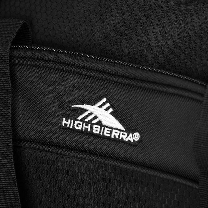 A close-up of a black duffel bag with a textured surface and a logo on the side.