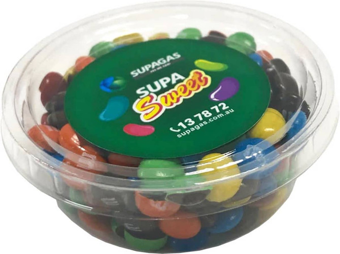 A clear tub filled with a variety of M&Ms in multiple colours, featuring a green lid with a logo.