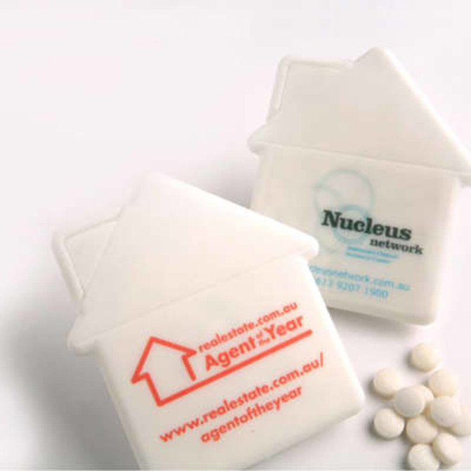 A house-shaped mint card in white with orange and teal branding, accompanied by small round mints.