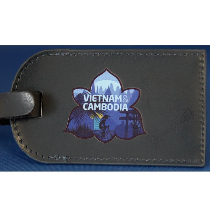 A dark luggage tag featuring a floral design and an illustration representing Vietnam and Cambodia.