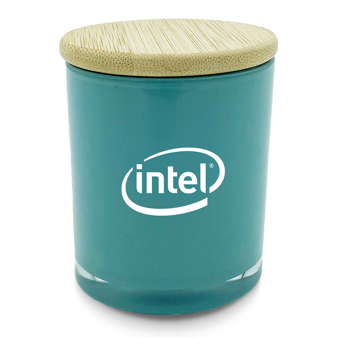 A large teal candle with a bamboo lid and a logo on the front.