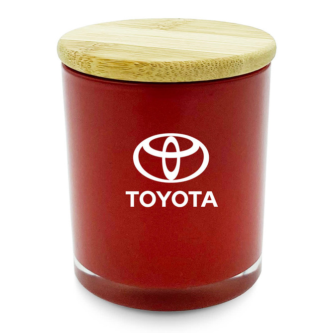 A medium red candle with a bamboo lid and a logo on the front.