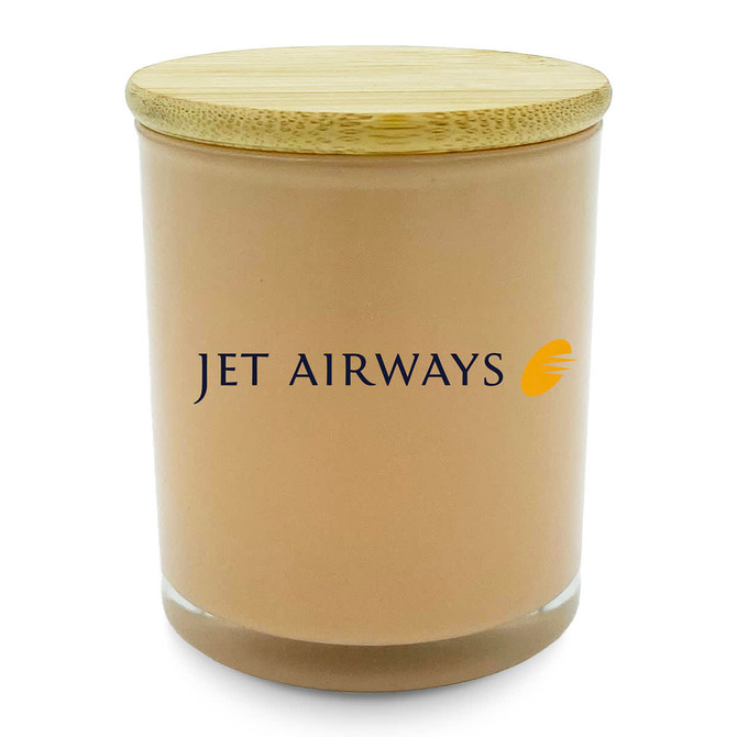 A medium relax candle in a peach-coloured glass jar with a bamboo lid and a branding logo.