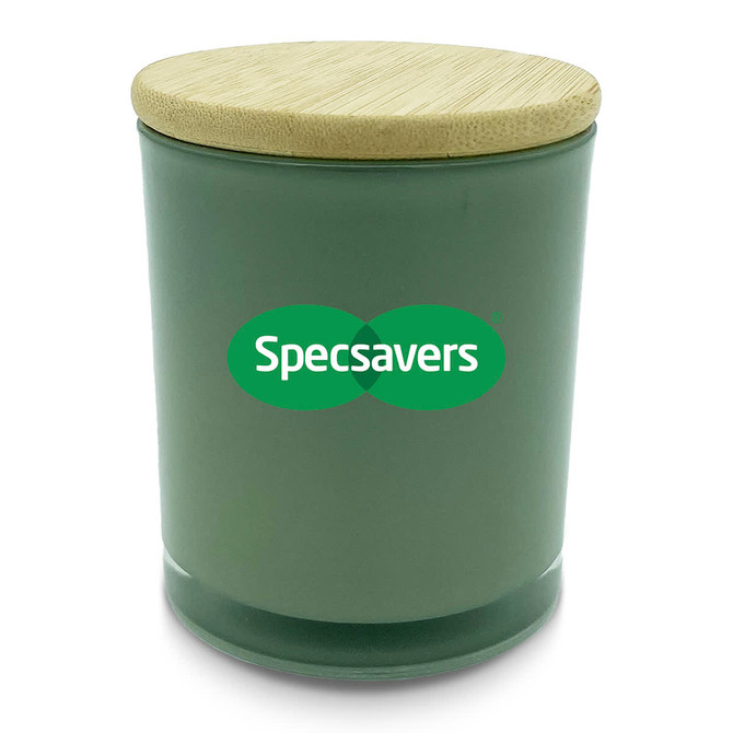 A medium green candle with a bamboo lid and a logo on the front.