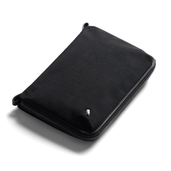 A black toiletry bag with a zip closure and a small logo. It features a sleek, minimalist design.