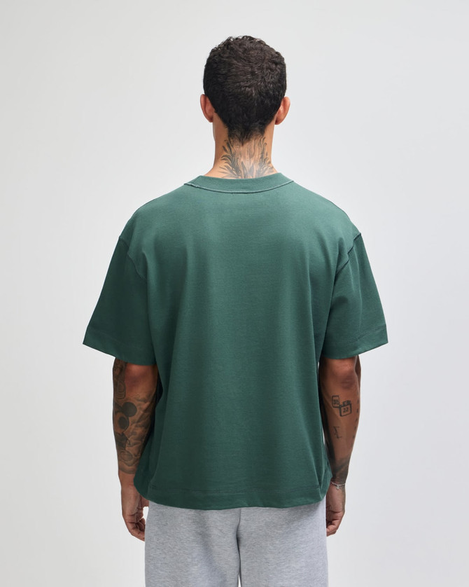 A green heavyweight cotton unisex boxy T-shirt viewed from the back, featuring a casual fit.