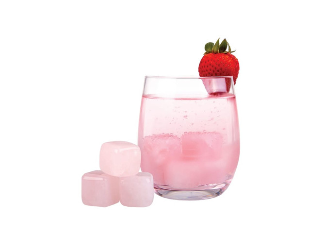 A glass of pink drink with a strawberry on the rim, alongside three rose quartz gin stones.