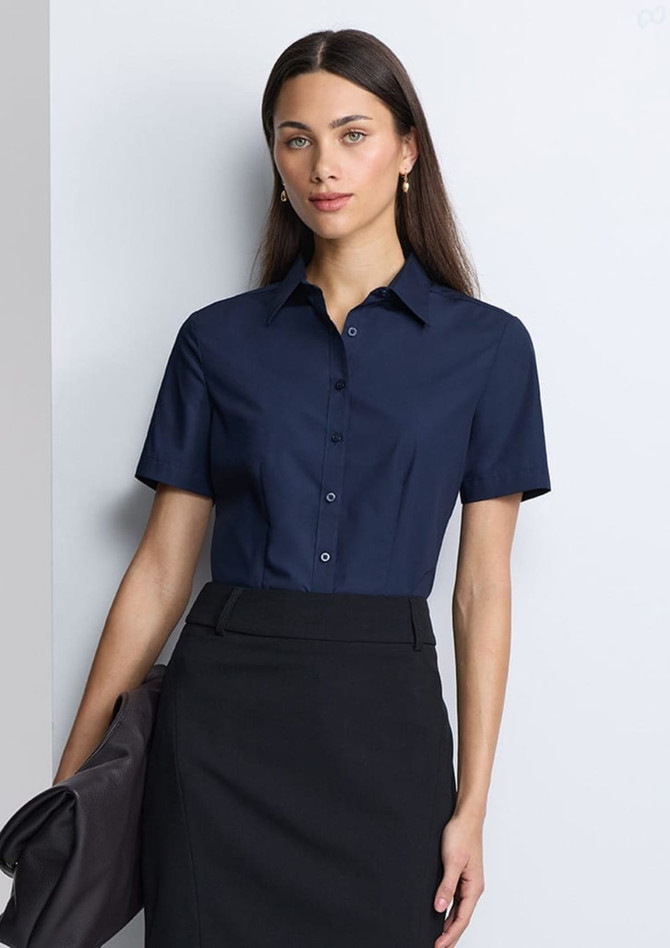 A navy women's short sleeve shirt with a collared neckline and buttons, paired with a black skirt.