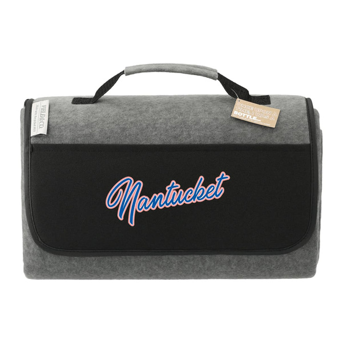 A grey picnic rug with a black flap and a logo. It features a handle for easy transport.
