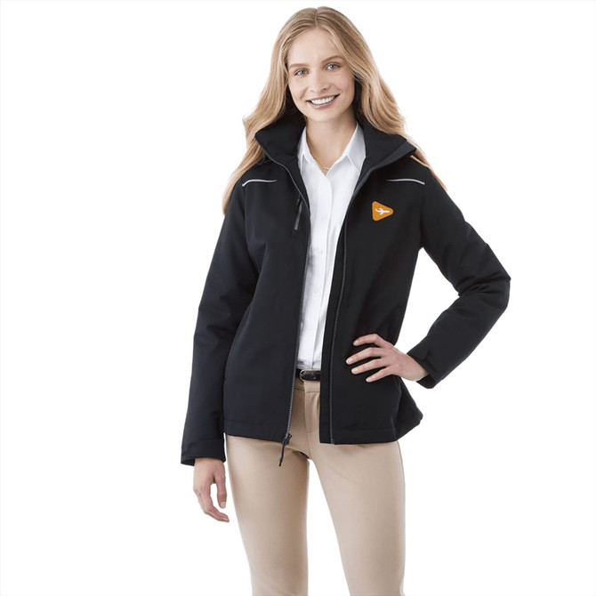 A woman wearing a black fleece lined jacket with a logo, styled with cream pants and a white shirt.