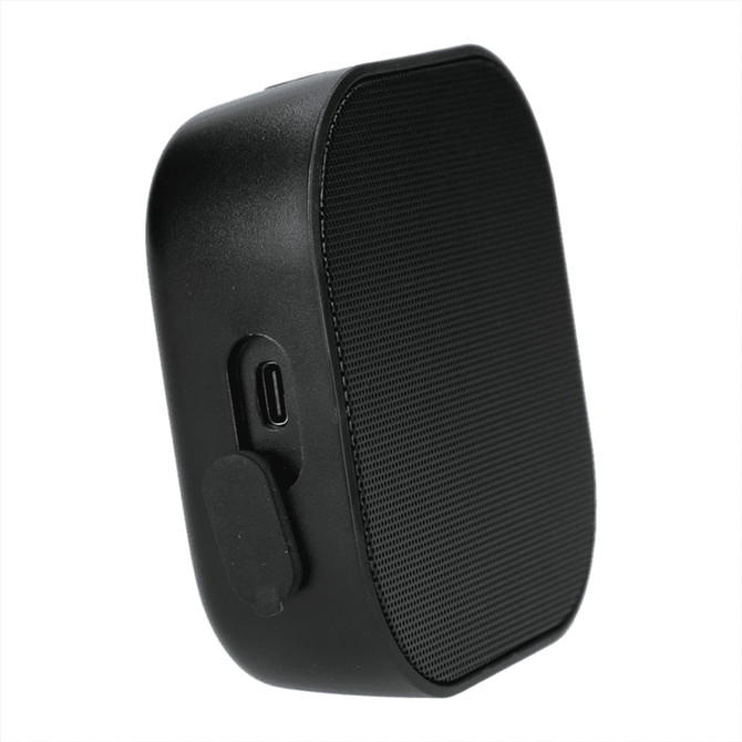 A black Bluetooth speaker with a textured front, featuring a charging port on the side and a logo on the surface.