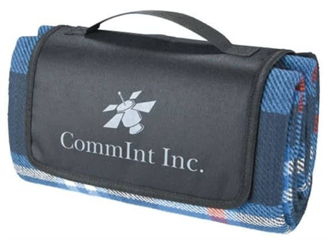 A folded blue picnic rug with a black carrying handle and a logo on the surface.