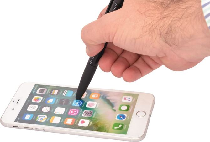 A black 6-in-1 multi pen being used as a stylus on a smartphone screen, featuring a hand and a mobile device.