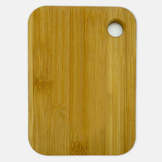 A bamboo cutting board in a rectangular shape with a small hole for hanging.